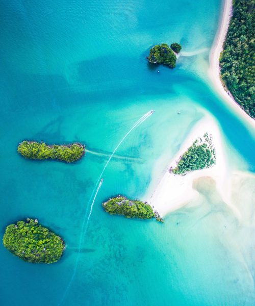 Sirithan Beach (sandy island) walking from the mainland (more right) in the water.